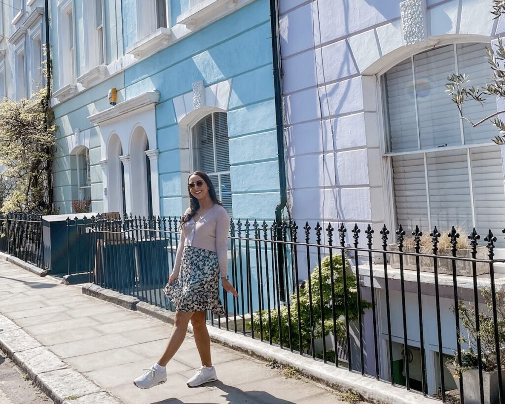 Pastel coloured street Notting Hill and girl posing